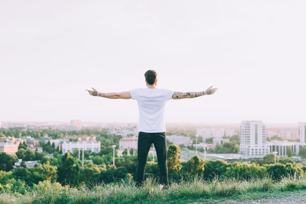 Successful man looking up to city scape sky celebrating enjoying freedom