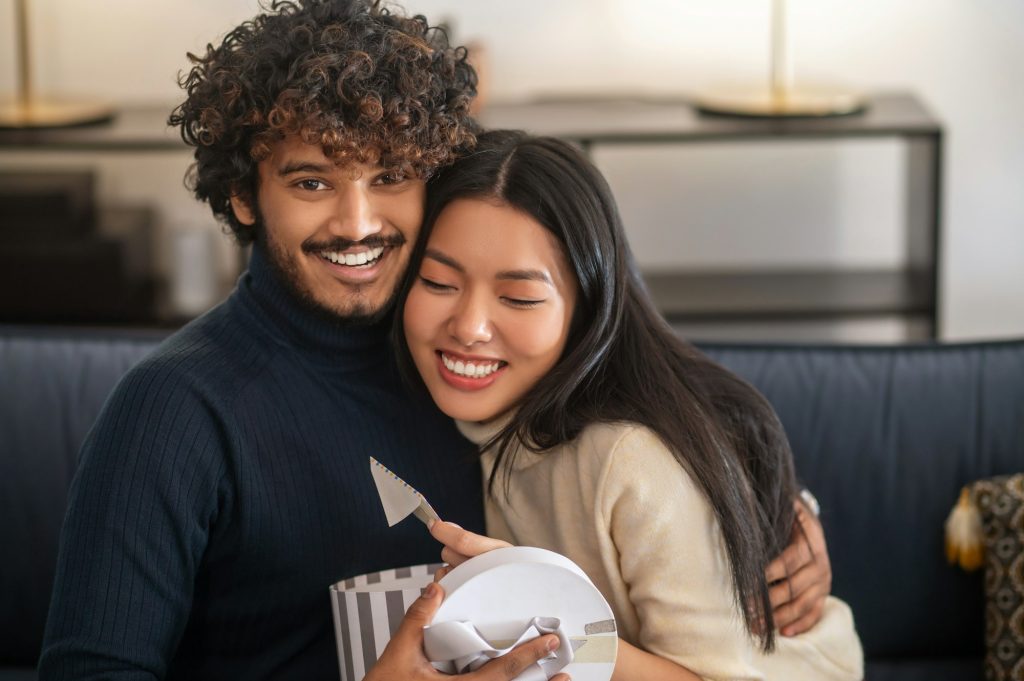 Man looking at camera hugging happy woman